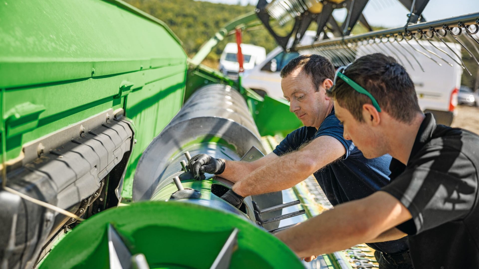 Koenig Equipment technicians servicing a John Deere combine header in the field