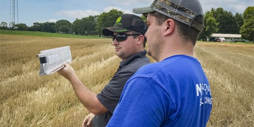 Two Koenig Equipment team members reviewing data on a tablet in a customer's field