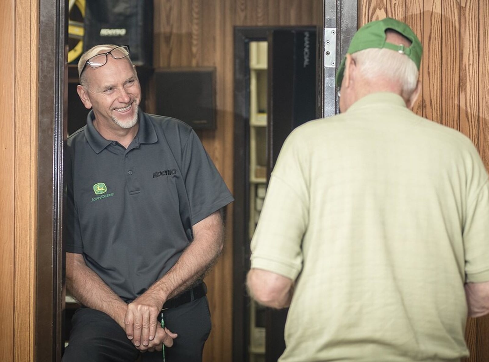 Two Koenig Equipment employees talking outside a store entrance