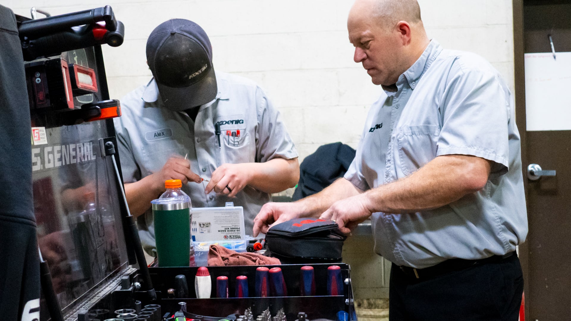 A Koenig Equipment technician training a student at a service toolbox