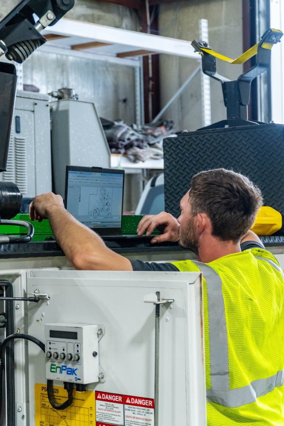 A Koenig technician running diagnostics on a laptop in the service shop