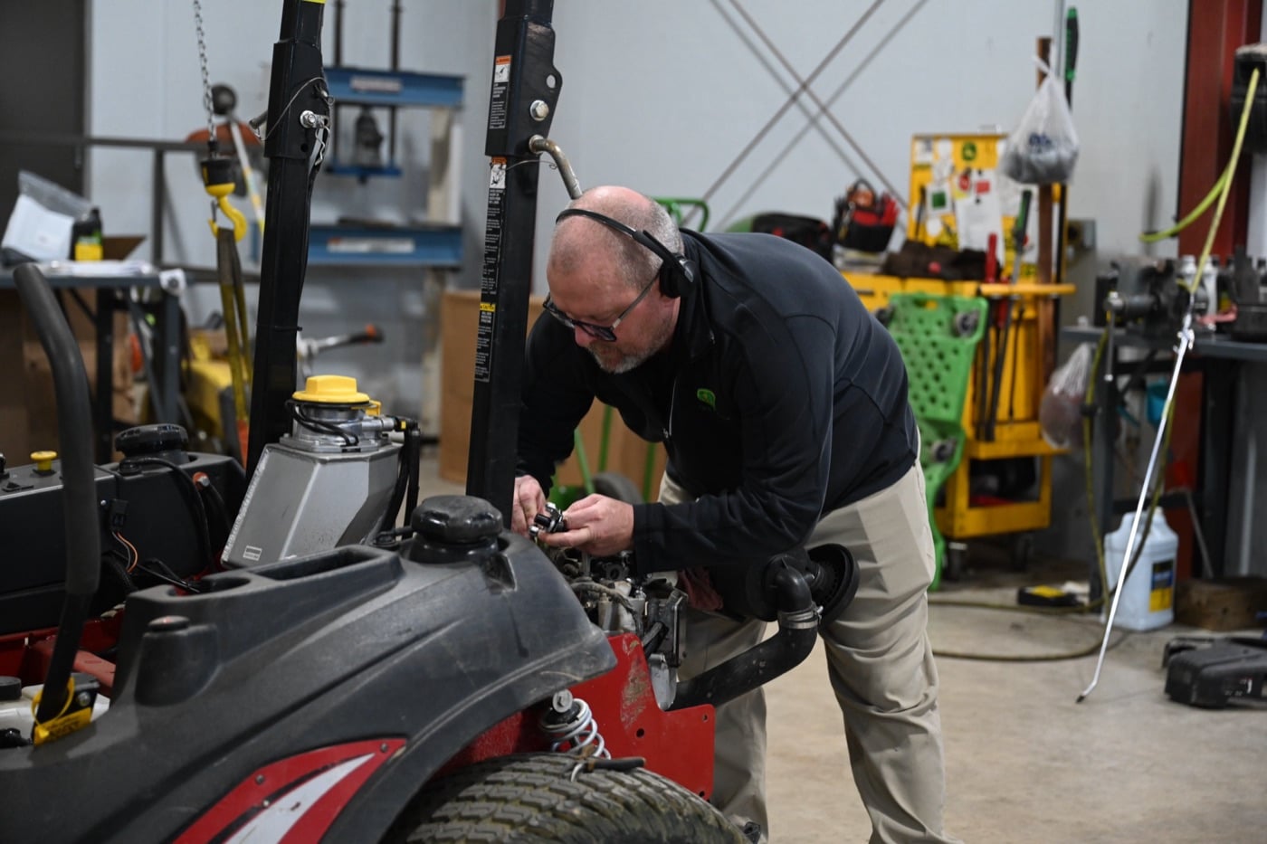 A Koenig Equipment technician servicing a zero-turn mower in the shop